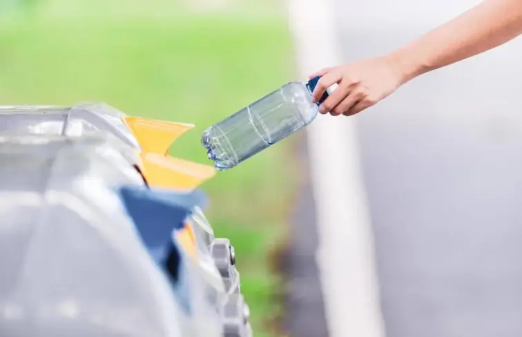 Pessoa a depositar elemento de plástico em ecoponto